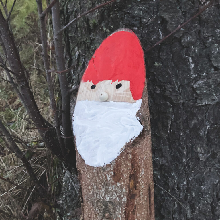 Ein Baumstamm, der wie ein Weihnachtsmann bemalt ist